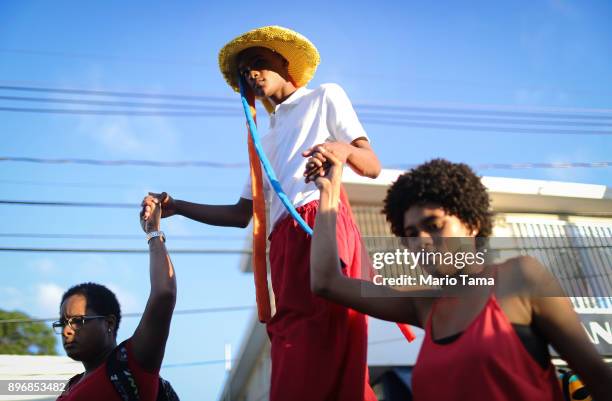 Teen marches on stilts during a student Christmas parade on December 21, 2017 in Loiza, Puerto Rico. The parade mixed traditional Catholic and...