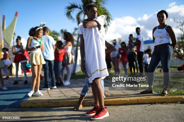 Student is dressed as the angel Gabriel before the start of a student Christmas parade on December 21, 2017 in Loiza, Puerto Rico. The coastal town...