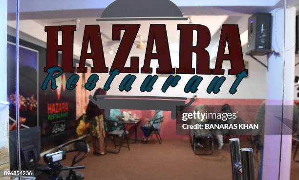 In this photograph taken on November 2 Pakistani diners eat at the "Hazara" restaurant in Hazara Town, a neighbourhood in Quetta. The outlet is named...