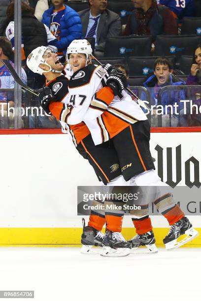 Hampus Lindholm of the Anaheim Ducks celebrates his overtime game-winning goal against the New York Islanders with teammate Ryan Getzlaf following a...