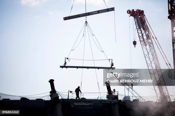 Man works at the construction site for the new National Stadium, venue for the upcoming Tokyo 2020 Olympic Games, in Tokyo on December 22, 2017....