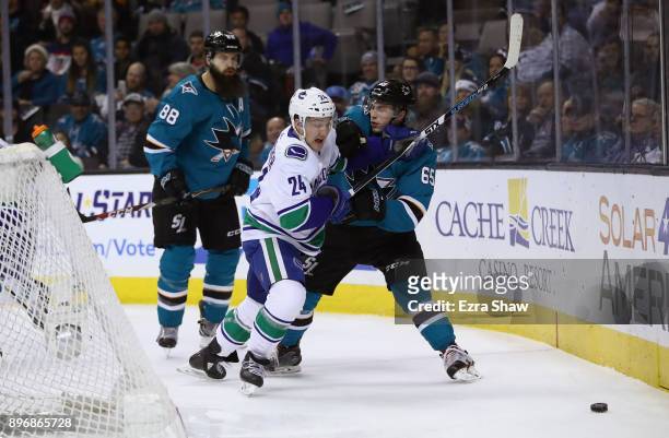 Reid Boucher of the Vancouver Canucks and Daniel O'Regan of the San Jose Sharks go for the puck at SAP Center on December 21, 2017 in San Jose,...
