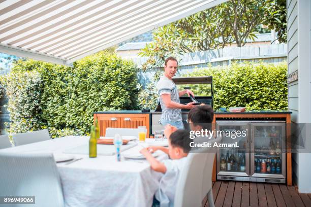 family enjoying lunch - outdoor kitchen stock pictures, royalty-free photos & images