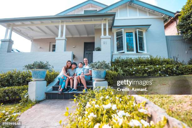 sitting in front of their home - australian family home stock pictures, royalty-free photos & images