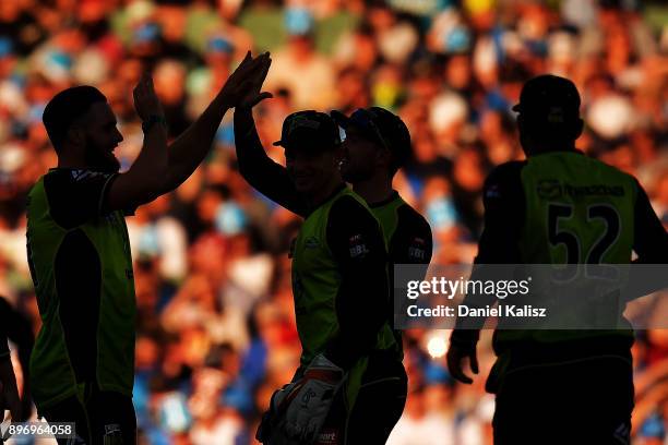 Mitchell McClenaghan of the Sydney Thunder celebrates with his team mates after taking the wicket of Jake Weathered of the Adelaide Strikers during...