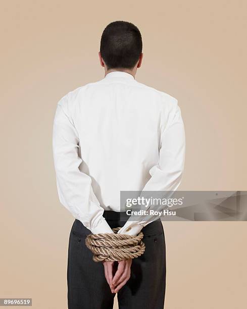 businessman with his hands tied behind his back - hands tied up stock pictures, royalty-free photos & images