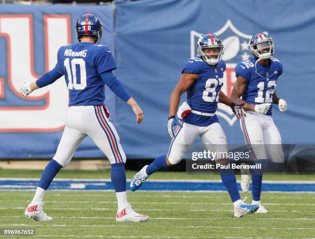 Eli Manning, Sterling Shepard and Tavarres King of the New York Giants celebrate a touchdown by Shepard in an NFL football game against the...