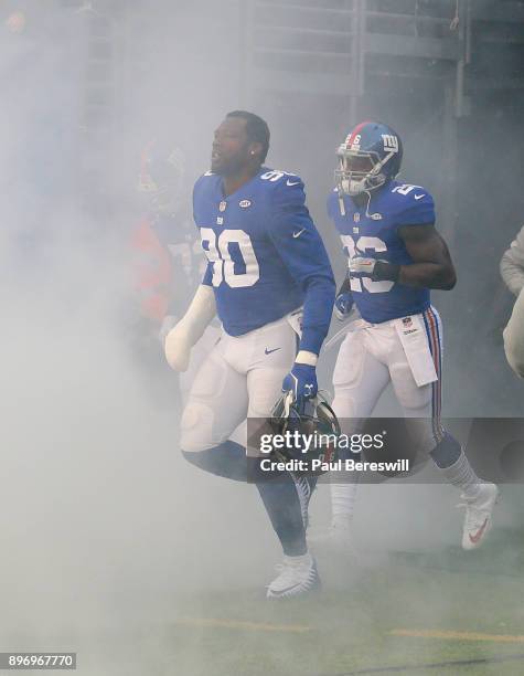 Jason Pierre-Paul of the New York Giants runs onto the field in a cloud of smoke during introductions before an NFL football game against the...