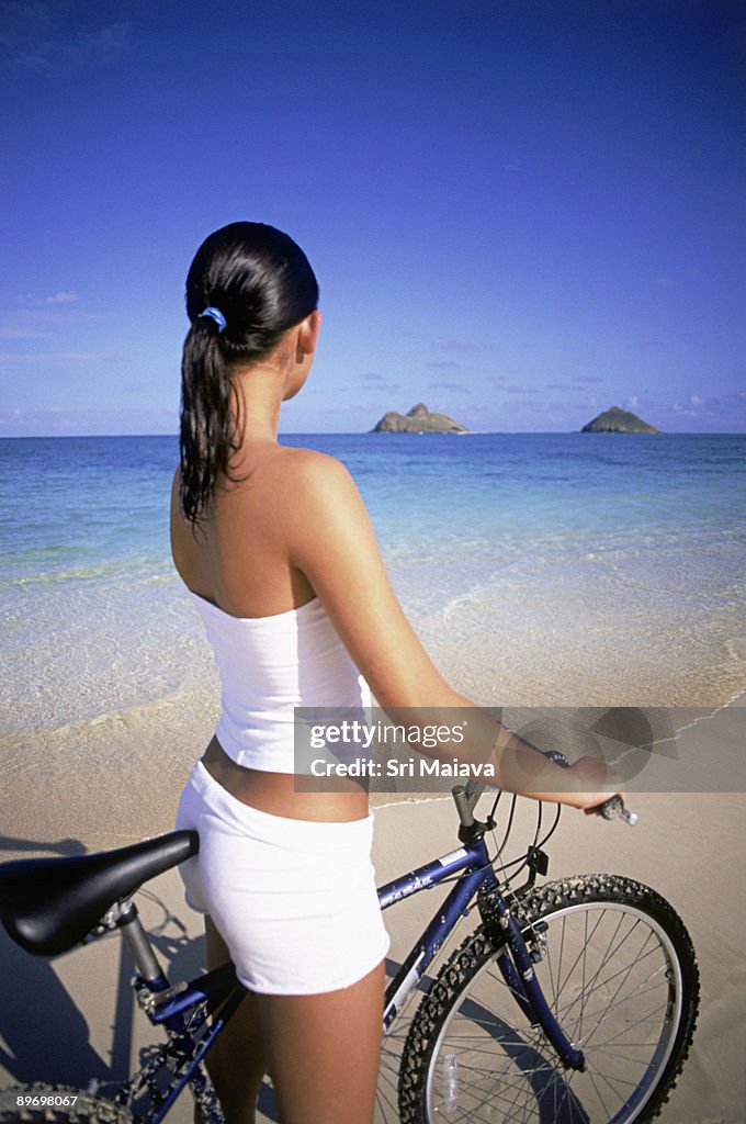 Woman with bicycle at beach