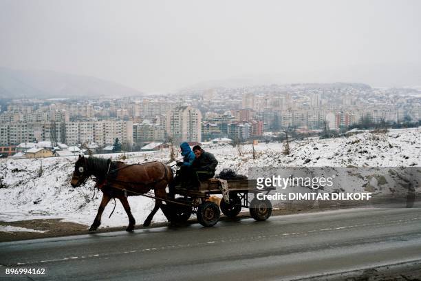 Men ride on a horse cart in the predominantly-Roma suburb of Fakulteta on the outskirts of Sofia on December 20, 2017. Bulgaria's capital Sofia is...