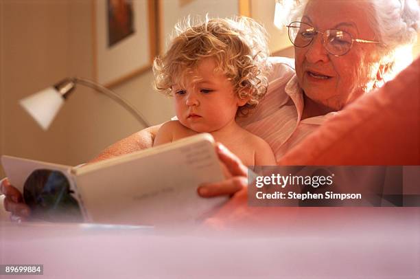 grandmother reading to granddaughter - chubby granny foto e immagini stock