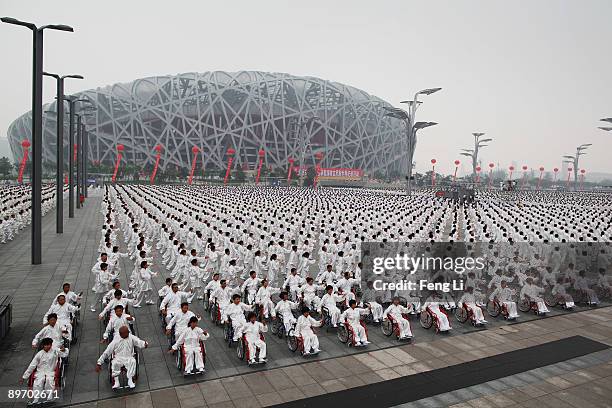 People take part in an attempt to break the Guinness world record for the largest number of people practising Taiji outside the National Olympic...