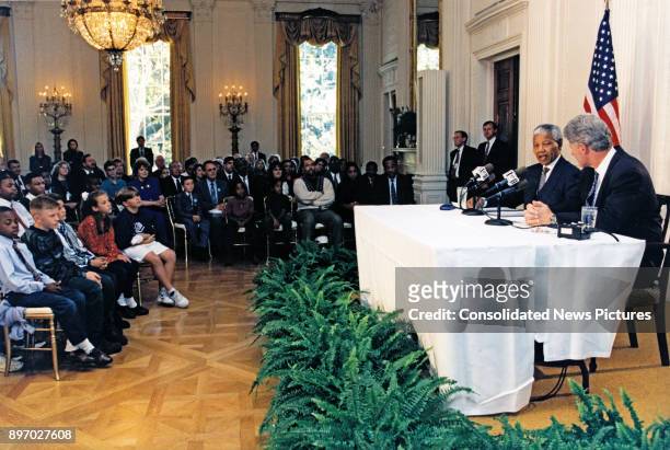South African President Nelson Mandela and US President Bill Clinton give a joint radio address in the White House's East Room, Washington DC,...