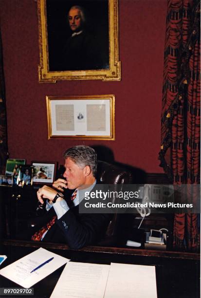 American politician US President Bill Clinton speaks on the telephone from his study in the White House residence, Washington DC, September 21, 1993....