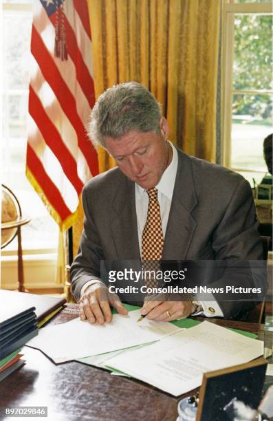 American politician US President Bill Clinton signs and Executive Order in the White House's Oval Office, Washington DC, August 6, 1996. The order,...