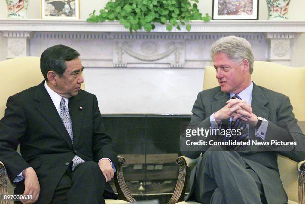 Japanese Foreign Minister Yohei Kono and US President Bill Clinton talk together in the White House's Oval Office, Washington DC, February 18, 2000.