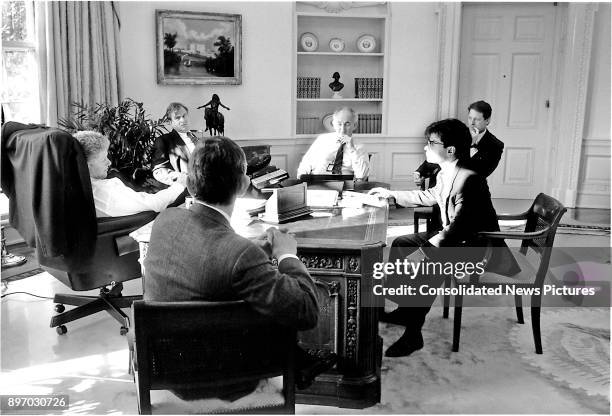 American politician US President Bill Clinton confers with advisors during a meeting in the White House's Oval Office, Washington DC, January 29,...