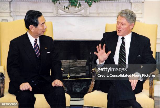 Japanese Foreign Minister Yukihiko Ikeda and US President Bill Clinton talk together in the White House's Oval Office, Washington DC, January 19,...