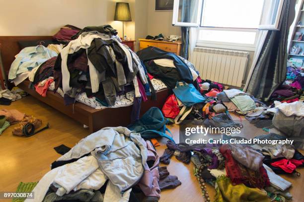 messy bedroom with clothes and possessions thrown around - chaos to order ストックフォトと画像