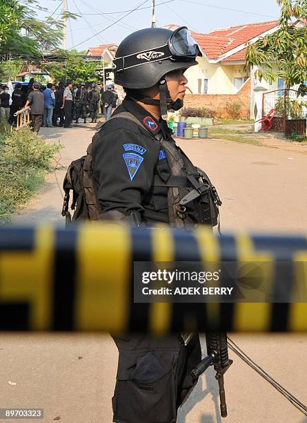 An Indonesian anti terror policemen stands guard near a suspected terrorist house in Bekasi near Jakarta on August 8, 2009. Two would-be suicide...