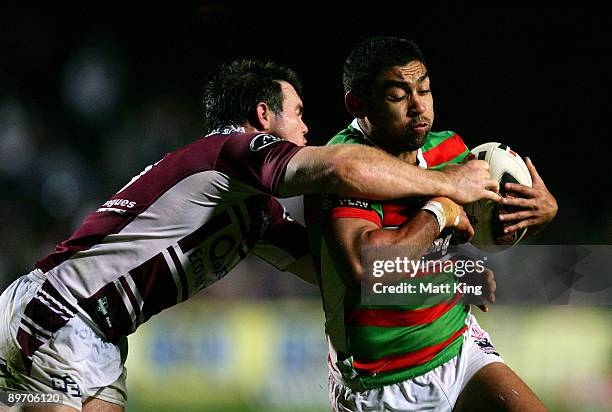 Nathan Merritt of the Rabbitohs is tackled by Jamie Lyon of the Sea Eagles during the round 22 NRL match between the Manly Warringah Sea Eagles and...