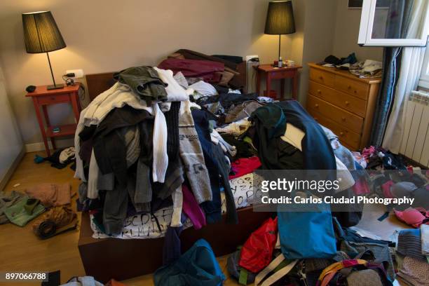 piles of clothes scattered on the bed and floor of a messy room - overflowing closet stock pictures, royalty-free photos & images