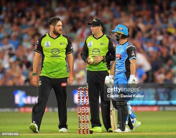 Mitchell McClenaghan and Ben Rohrer of the Sydney Thunder speak with Jake Weathered of the Adelaide Strikers during the Big Bash League match between...