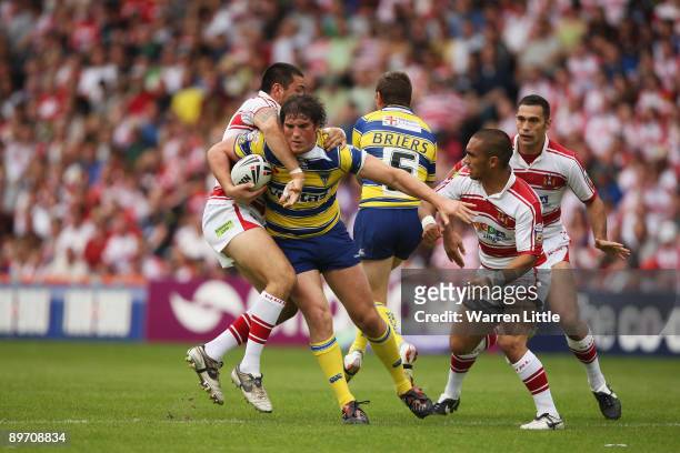 Ben Harrison of Warrington is tackled during the semi-final match of the Carnegie Challenge Cup between Wigan Warriors and Warrington Wolves at the...