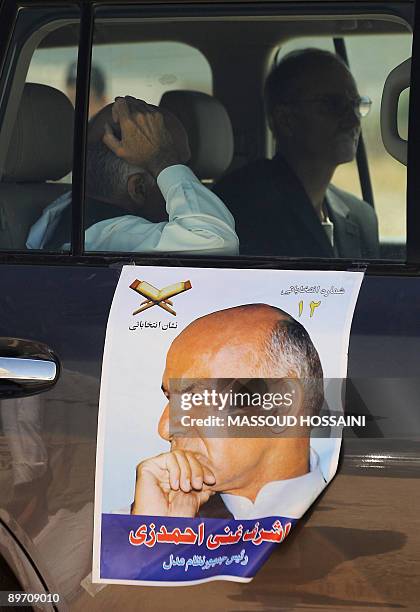 Afghan presidential candidate and former finance minister Ashraf Ghani rests in a car with his poster stuck on the door in Maymana city of the...