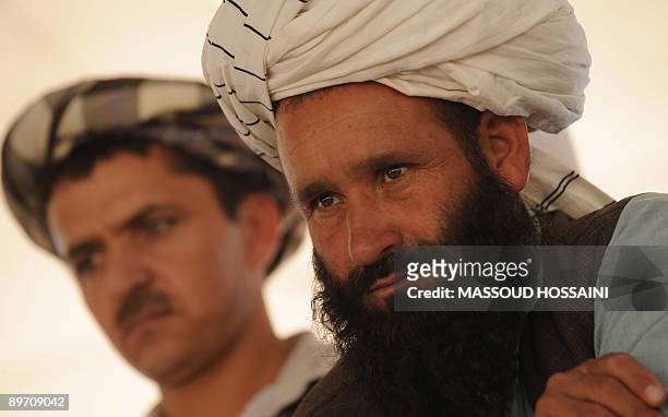 Afghan men listen to Afghan presidential candidate and former finance minister Ashraf Ghani during his campaigning event in Maymana city of the...