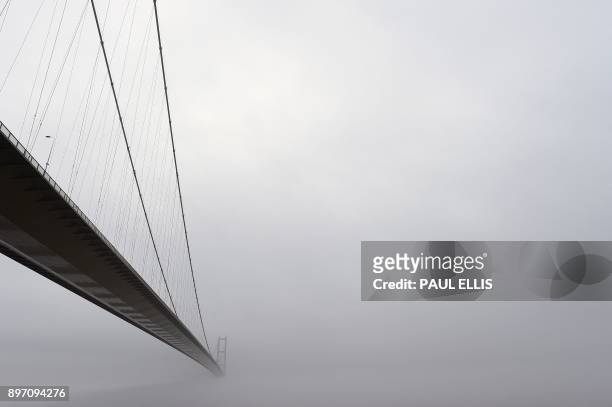 The Humber bridge near Hull in north east England is obscured by low cloud on December 22, 2017