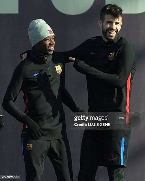 Barcelona's defender Gerard Pique jokes with Barcelona's French forward Ousmane Dembele during a training session at the Sports Center FC Barcelona...