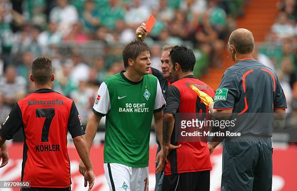 Referee Helmut Fleischer shows the yellow red card to Sebastian Proedl of Bremen during the Bundesliga match between Werder Bremen and Eintracht...
