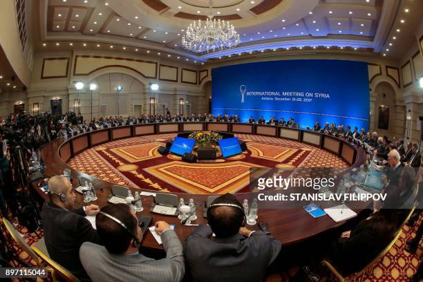 Syrian regime representatives and opposition delegates along with other attendees take part in the session of Syria peace talks in Astana on December...
