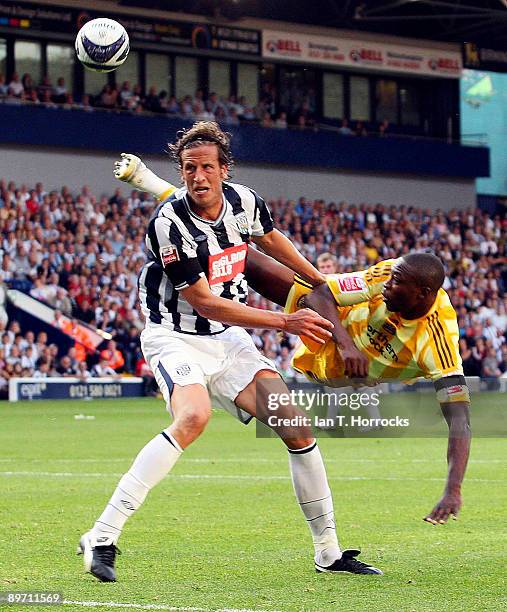 Shola Ameobi of Newcastle tussles with Jonas Olsson of West Brom during the Coca-Cola Championship match between West Bromwich and Newcastle United...