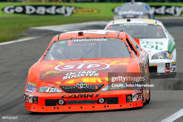 Marcos Ambrose, driver of the STP Toyota, leads Jeff Burton, driver of the Holiday Inn Chevrolet, and Kevin Harvick, driver of the Copart Chevrolet,...