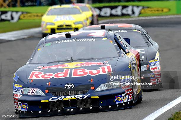 Scott Speed, driver of the Red Bull Toyota, races with Kevin Harvick, driver of the Copart Chevrolet, during the NASCAR Nationwide Series Zippo 200...