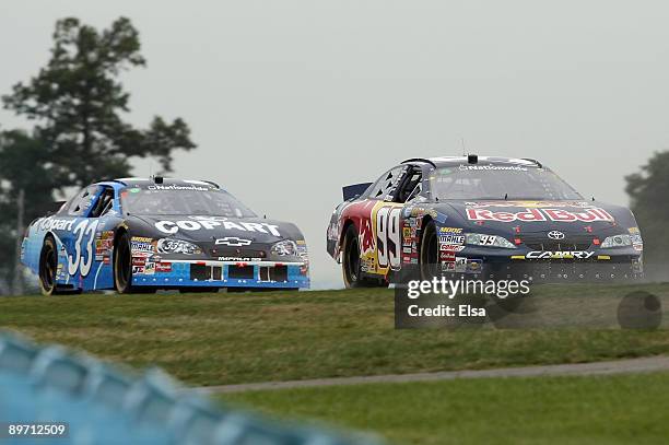 Scott Speed, driver of the Red Bull Toyota, races Kevin Harvick, driver of the Copart Chevrolet, during the NASCAR Nationwide Series Zippo 200 at...