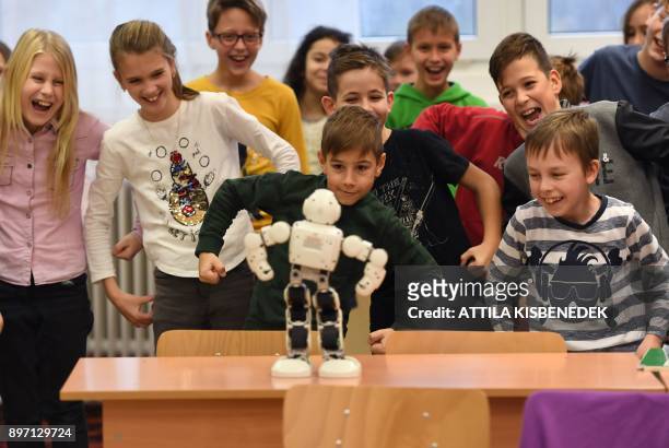 School children dance with 'Robi, the robot' in the classroom of a primary school in Szolnok, about 100 kilometres east of Budapest on December 13,...