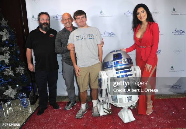 Model CJ Sparxx poses with a patient and R2D2 at A Children's Miracle Holiday Sponsored by Amity Medical Group and Vitamin Patch Club in Partnership...