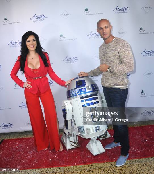 Model CJ Sparxx poses with fighter Steve Orosco and R2D2 at A Children's Miracle Holiday Sponsored by Amity Medical Group and Vitamin Patch Club in...