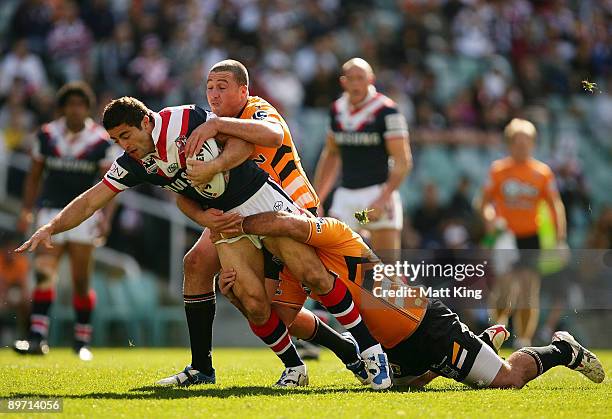 Anthony Minichiello of the Roosters is tackled during the round 22 NRL match between the Sydney Roosters and the Wests Tigers at the Sydney Football...