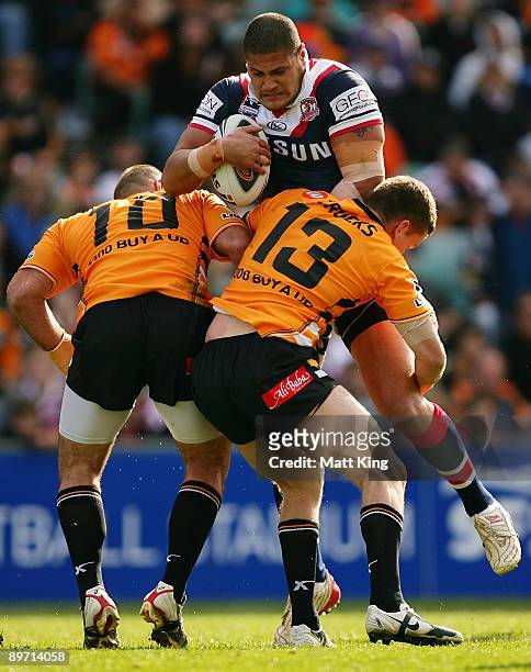 Willie Mason of the Roosters is tackled during the round 22 NRL match between the Sydney Roosters and the Wests Tigers at the Sydney Football Stadium...