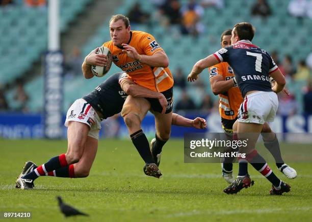 Gareth Ellis of the Tigers takes on the defence during the round 22 NRL match between the Sydney Roosters and the Wests Tigers at the Sydney Football...