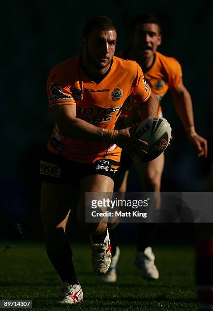 Robbie Farah of the Tigers runs with the ball during the round 22 NRL match between the Sydney Roosters and the Wests Tigers at the Sydney Football...