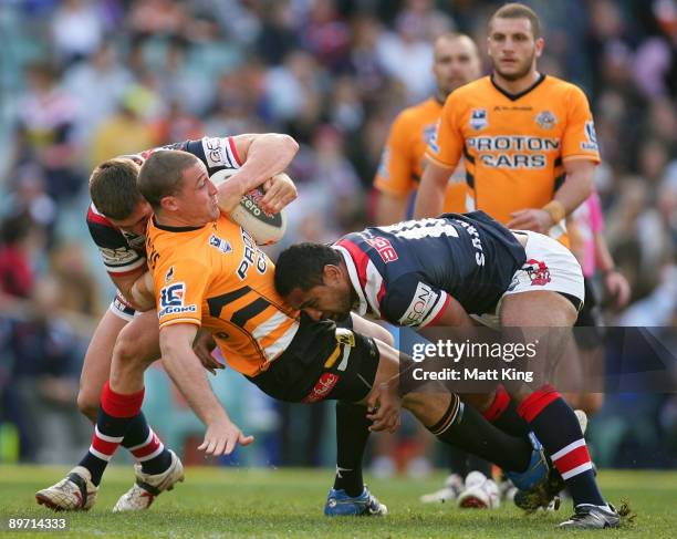 Bryce Gibbs of the Tigers is tackled during the round 22 NRL match between the Sydney Roosters and the Wests Tigers at the Sydney Football Stadium on...