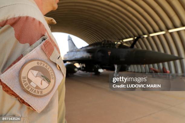 Picture taken on December 22, 2017 shows the badge of a member of the Barkhane mission standing next to a French air force aircrafts Mirage 2000 on...