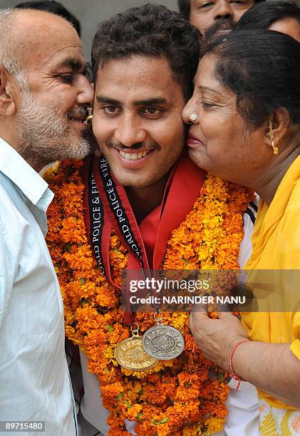 Personel from the Punjabi police, Vikram Sharma, , , is congratulated by his father Kamal Kishore Sharma , and mother Kanchan Sharma on his return...