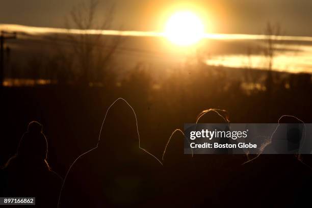 People gather for a sunset winter solstice celebration at the UMass Amherst Sunwheel in Amherst, MA on Dec. 21, 2017.