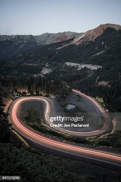 long exposure of traffic going up and over red mountain pass on the million dollar highway on a summer night - million dollar highway stock-fotos und bilder